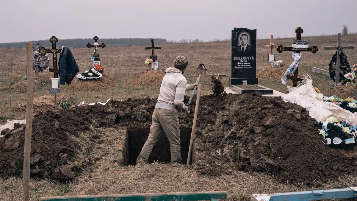 Мужчина роет могилу в начале марта на новом участке кладбища в Макове. Фото: Элис Мартинс для The Washington Post