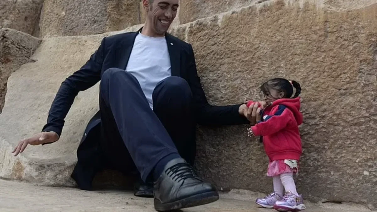 Одна из вчерашних фотографий отражает их фотосессию 2018 года в Египте, поскольку на ней Косен сидит на полу, а Амге стоит рядом с ним, но, несмотря на значительное снижение роста после того, как он сел, он все еще возвышается над ней. Фото: Getty

