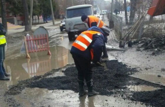 Асфальтом засыпают лужи