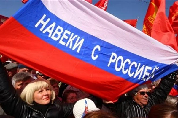 Митингующие держат в руках флаги Крыма, России и Георгиевские флаги. Они выкрикивают «Россия!» и «Беркут!»