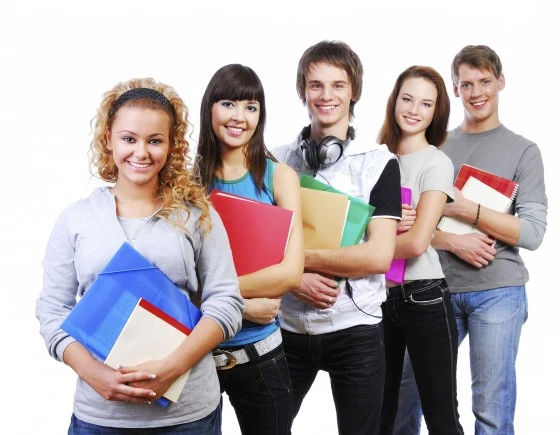 row of smiling students standing with books - white background