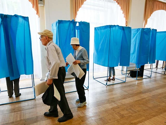 People fill out ballots in booths during voting in a presidential election at polling station in Kiev Избирательные участки на Украине работают так же, как и в России - с 8 утра до 8 вечера по местному времени, то есть до 21 мск. На пост президента претендует 21 кандидат